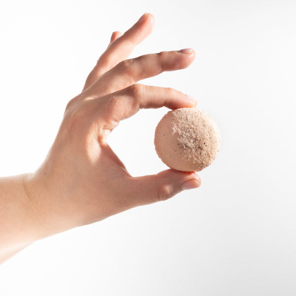 Hand holding a Macaron cookie to show the actual size