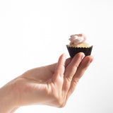 Hand holding a mini cupcake to show it's actual size