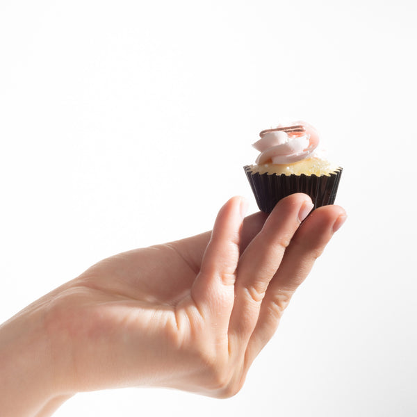 Hand holding a mini cupcake to show it's actual size